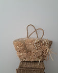 Bolso de mimbre con lazos y brillos.