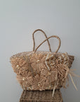 Bolso de mimbre con lazos y brillos.