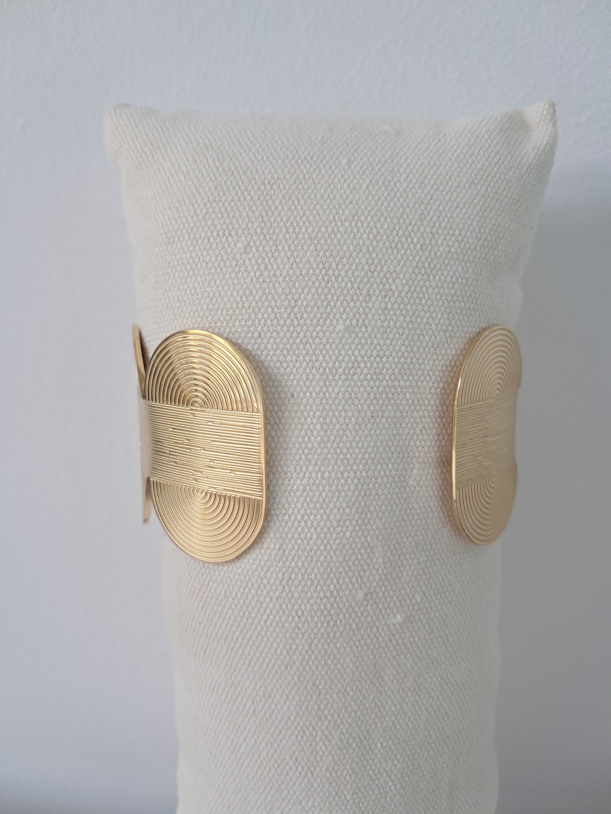 Pulsera dorada rígida con diseño geométrico en relieve